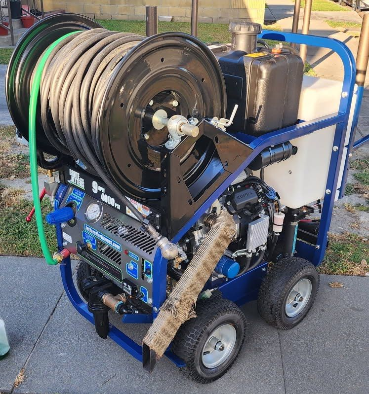 A man is fixing a drain in a bathroom with a hose.