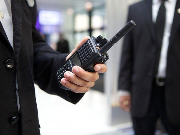 Man in security uniform communicating on a two-way radio