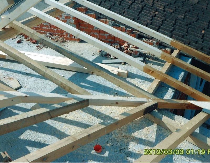 Moderna casa bianca con tetto spiovente, prato e un'auto parcheggiata davanti.