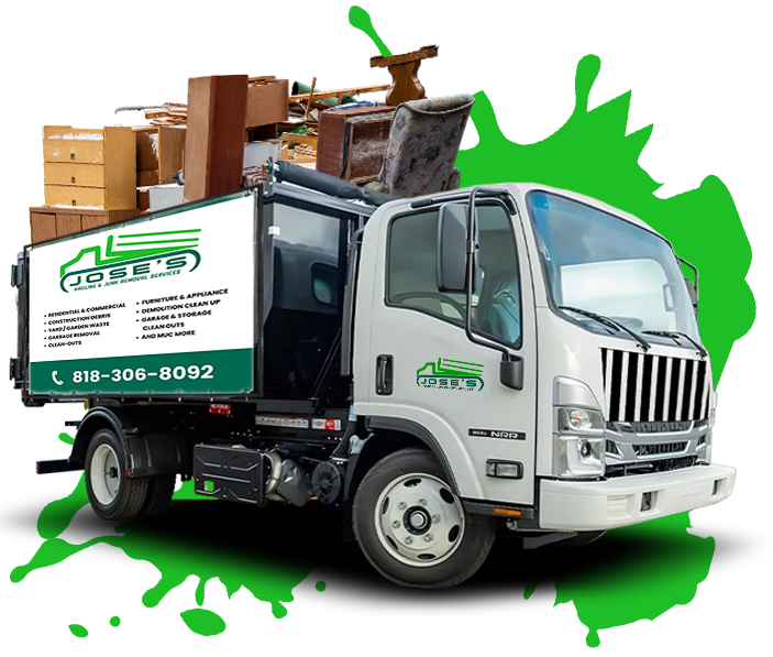 A garbage truck is filled with lots of furniture and boxes.