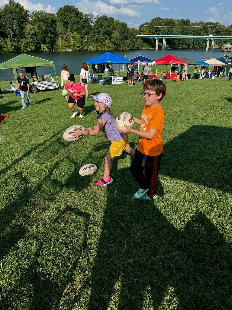 A boy and a girl are playing rugby at Meet the Mountains.