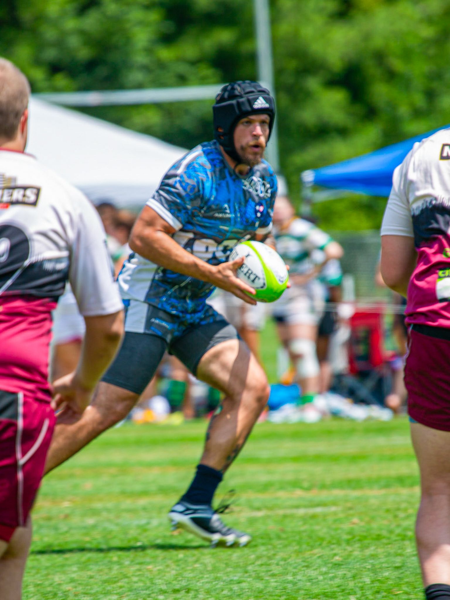 Rugby player carrying the ball under pressure during a competitive match in Johnson City, Tennessee