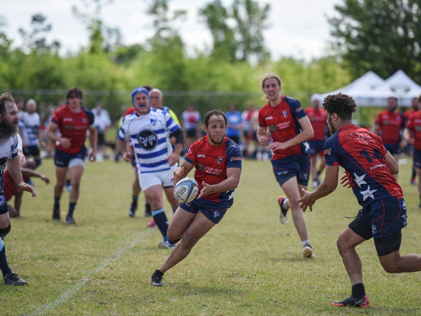 A group of people are playing rugby on a field.