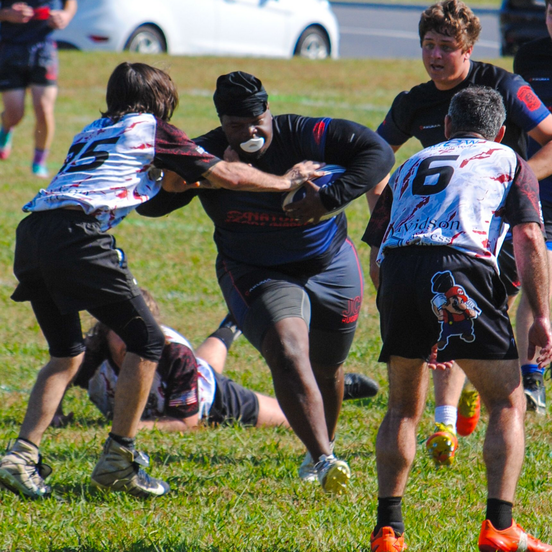 A group of people are playing rugby on a field.