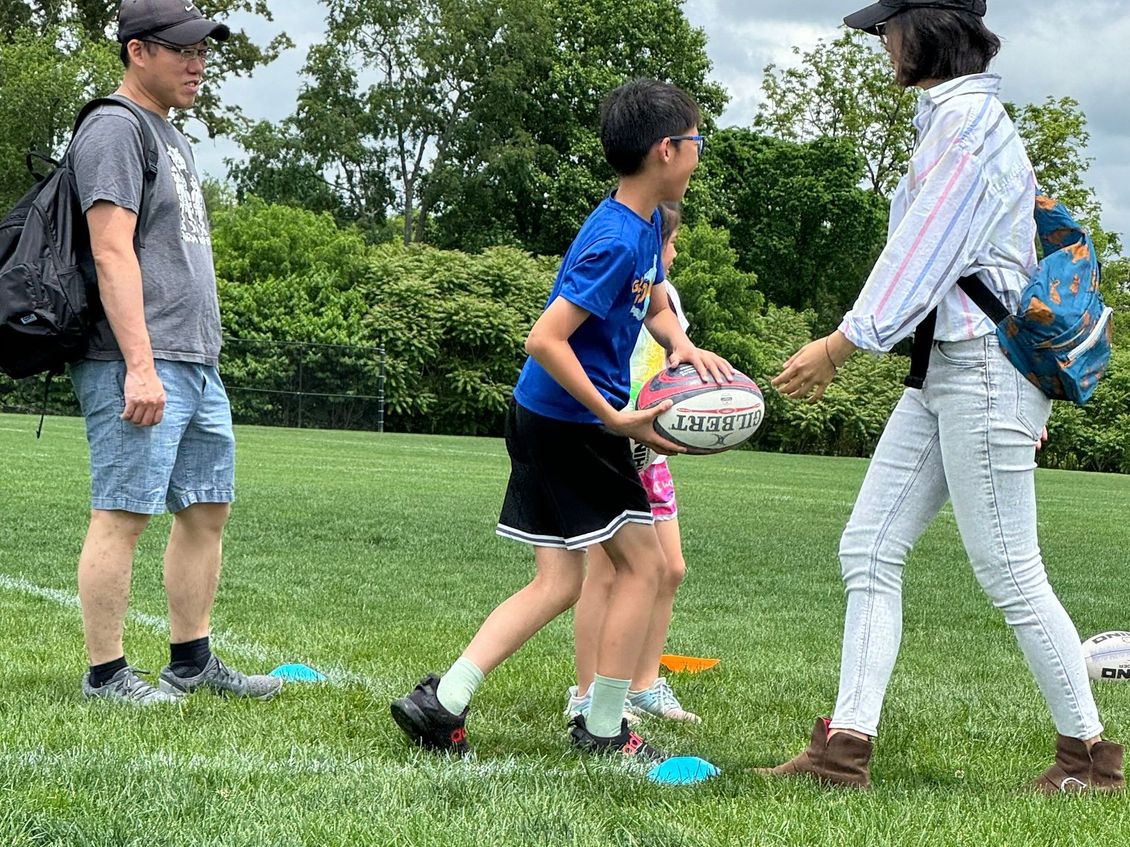 A group of people are playing rugby on a field.