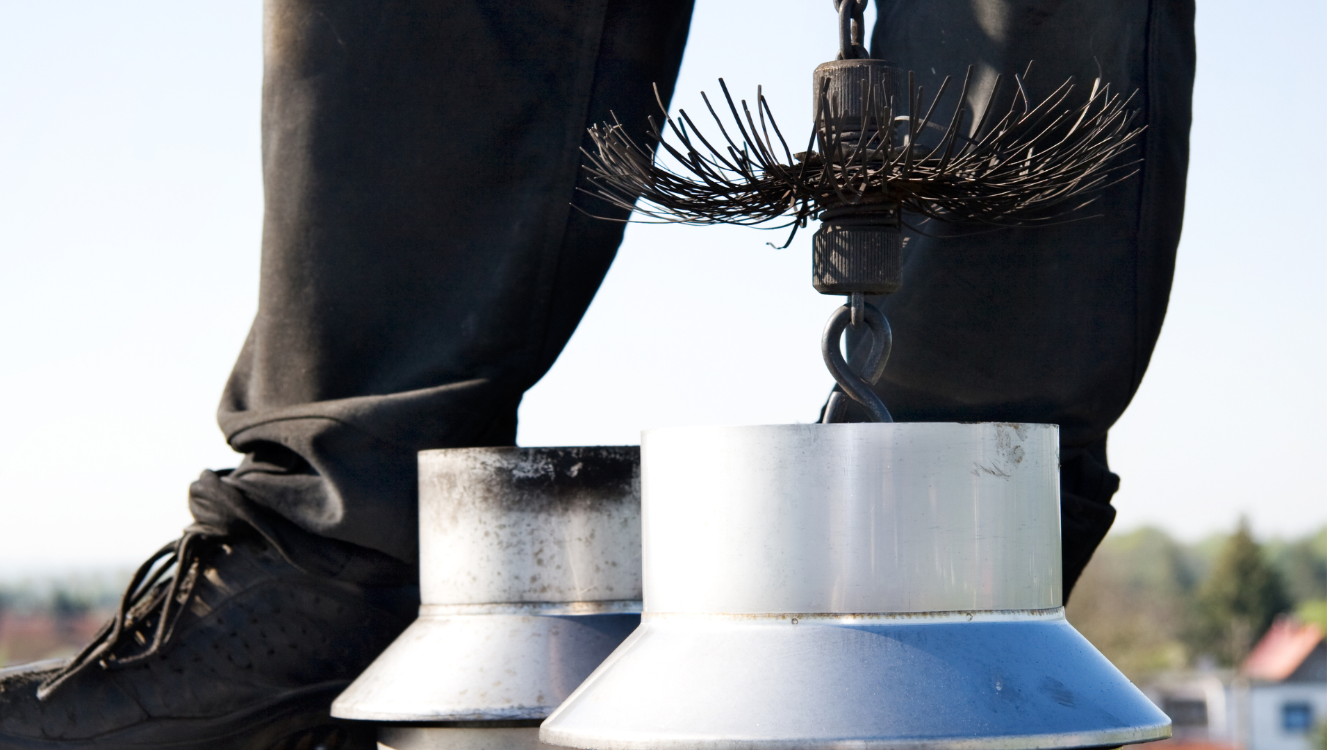 A person standing on top of a chimney with a brush on their leg
