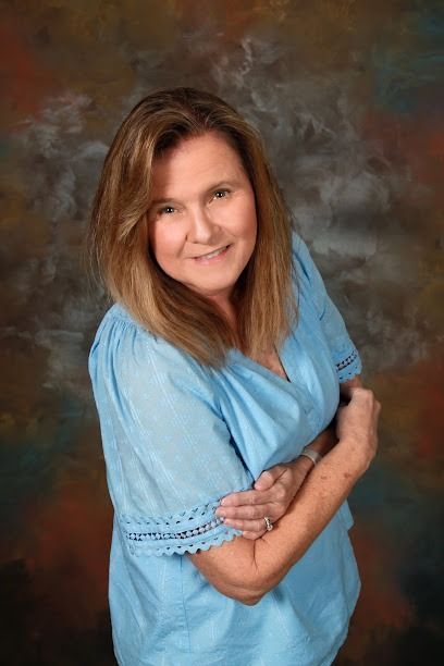 Two people reviewing financial data on a laptop and printed charts in a well-lit office.
