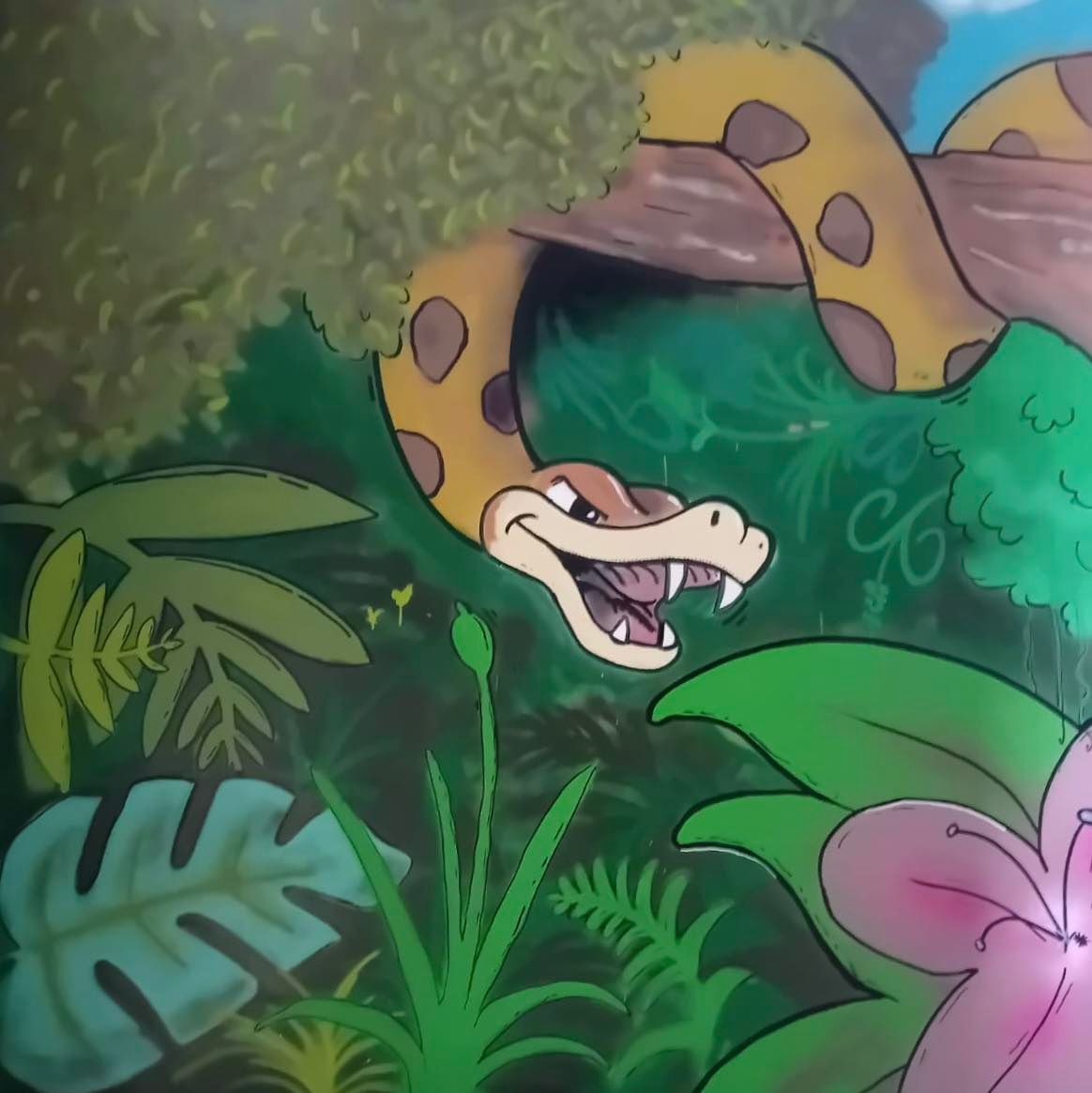 Serpente sorridente dei cartoni animati con macchie marroni e zanne, in un ambiente giungla con foglie verdi e fiori rosa.