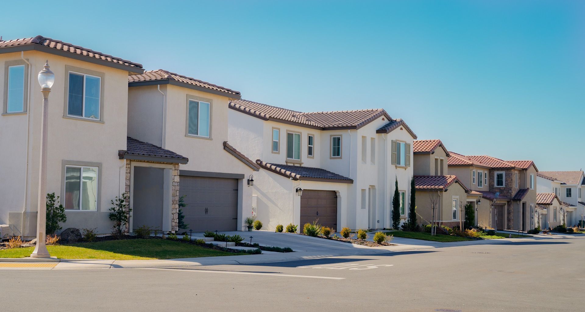 A row of houses in a residential area with a blue sky in the background.