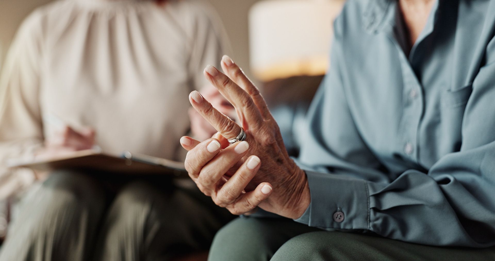 A woman is holding a ring in her hand while sitting next to another woman.