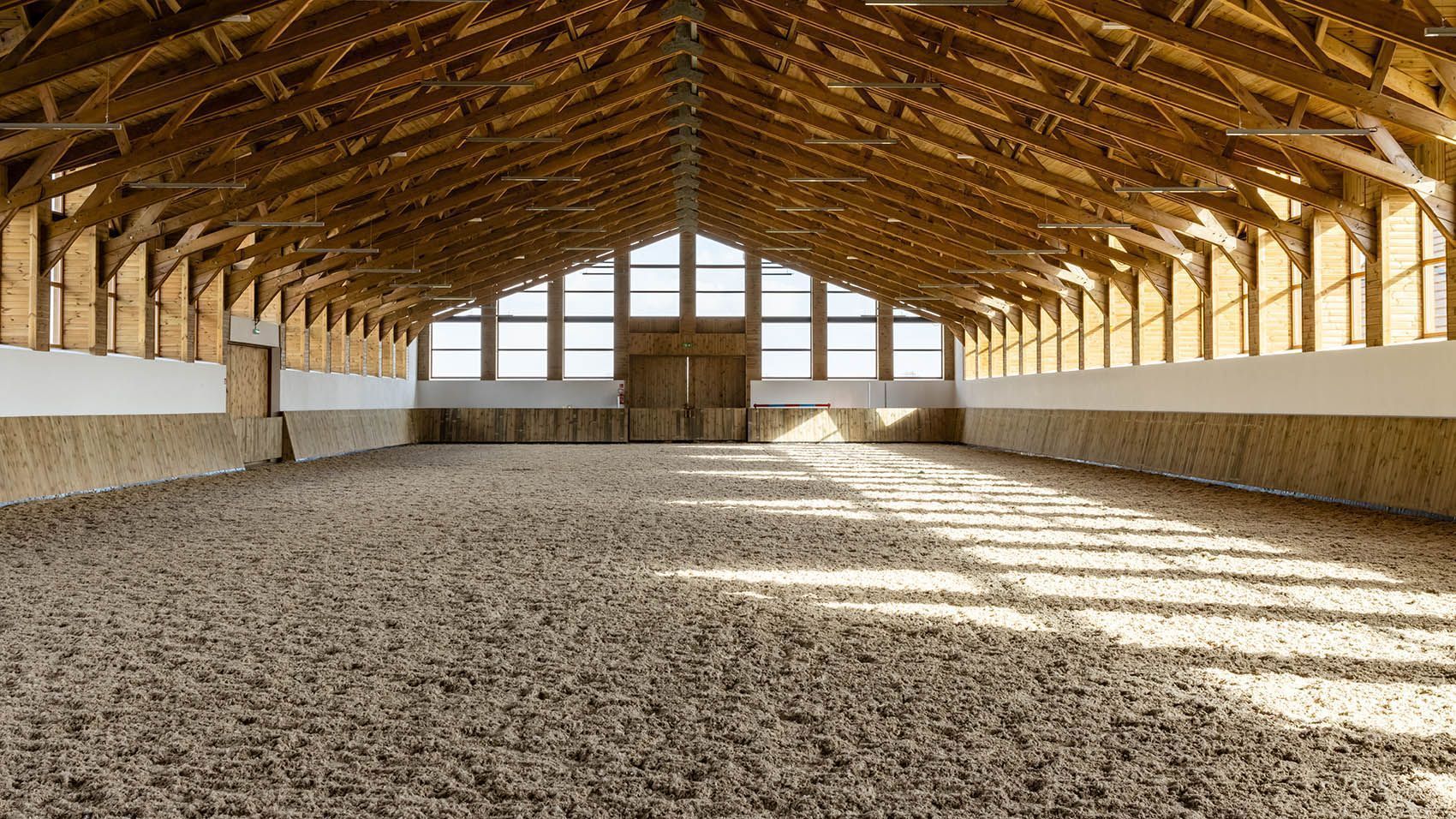 A man is riding a horse in an indoor arena.