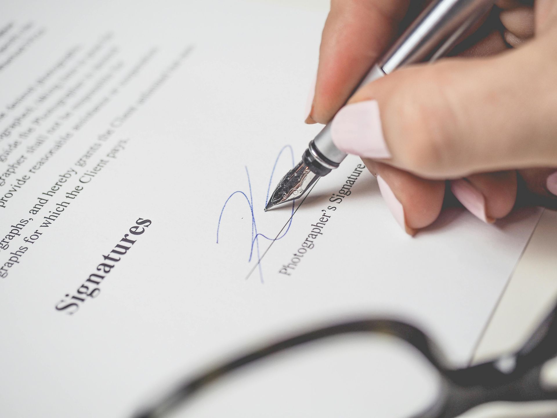 A person is signing a document with a fountain pen.