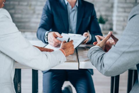 A group of people are sitting at a table having a meeting.