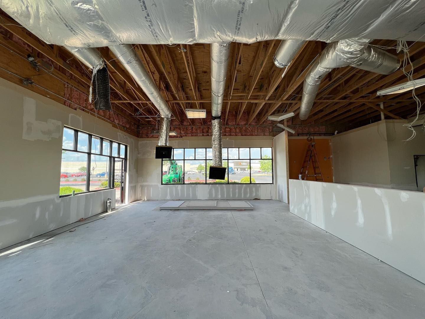 Interior of a building under construction, showing unfinished walls, ceiling, and concrete floor.