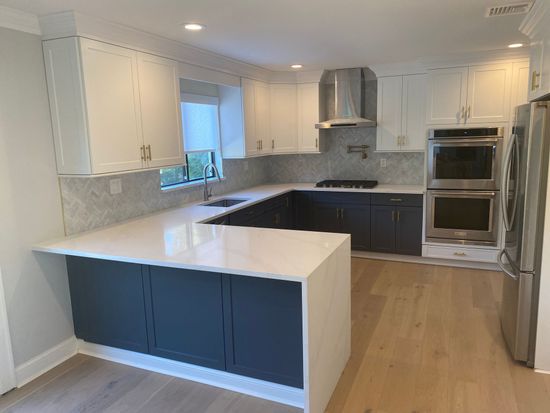 A kitchen with stainless steel appliances and white cabinets