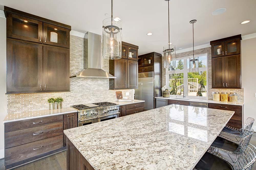 A kitchen with granite counter tops , stainless steel appliances , and wooden cabinets.