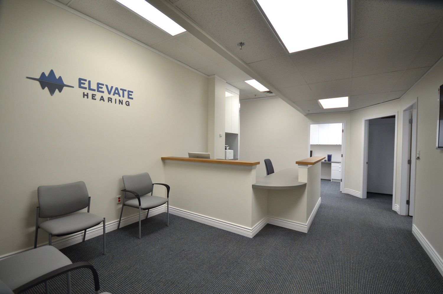 A waiting room with a sign on the wall that says elevate hearing