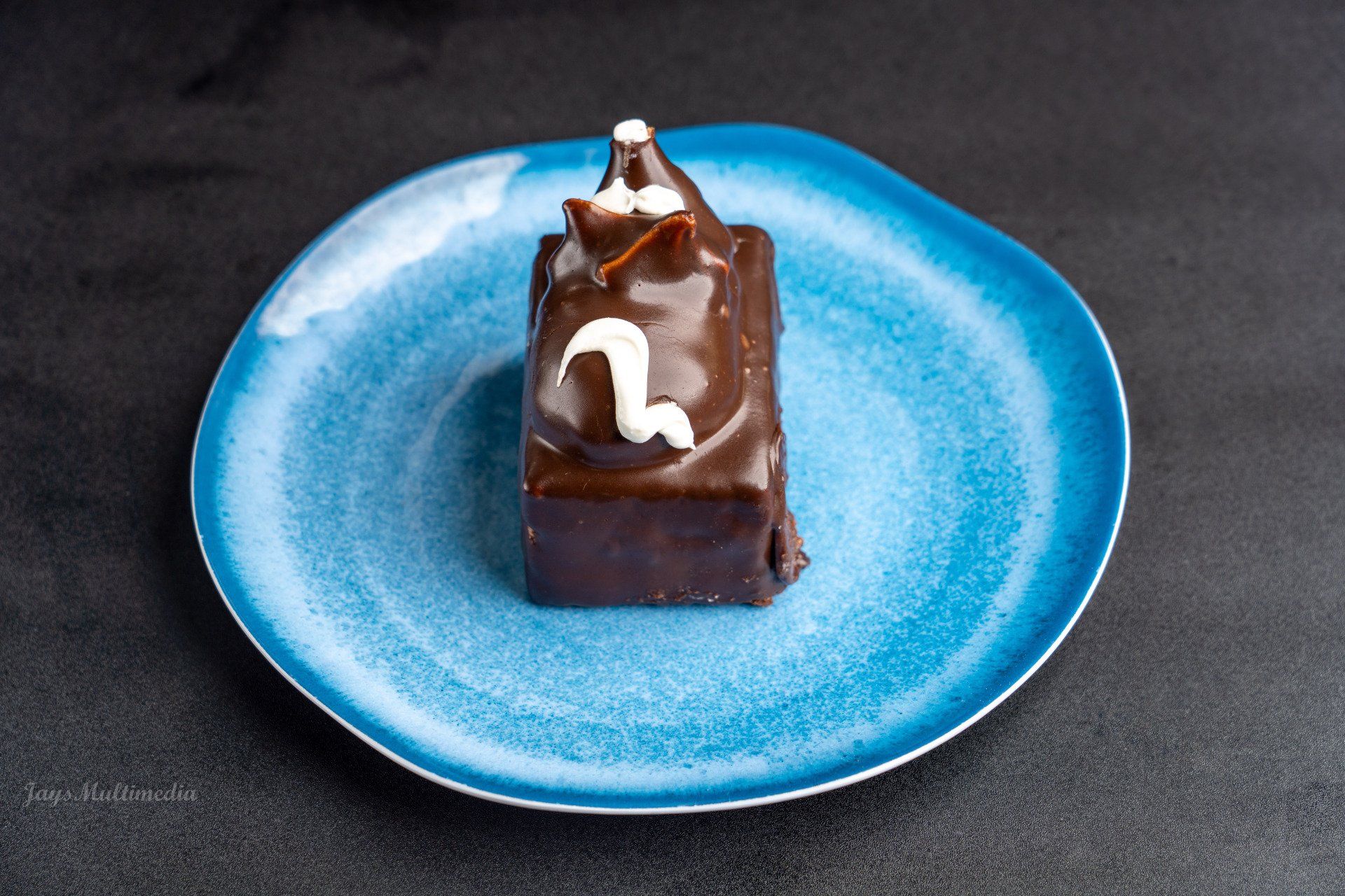 A piece of chocolate cake is on a blue plate.
