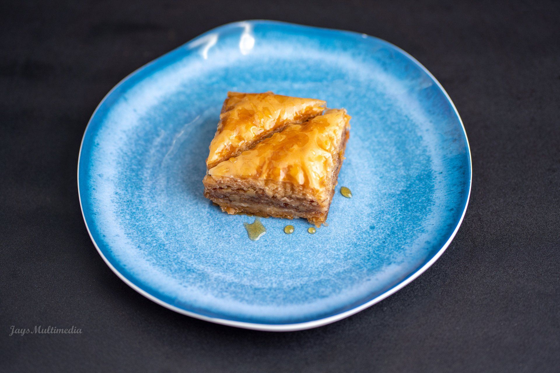 A blue plate with a piece of baklava on it