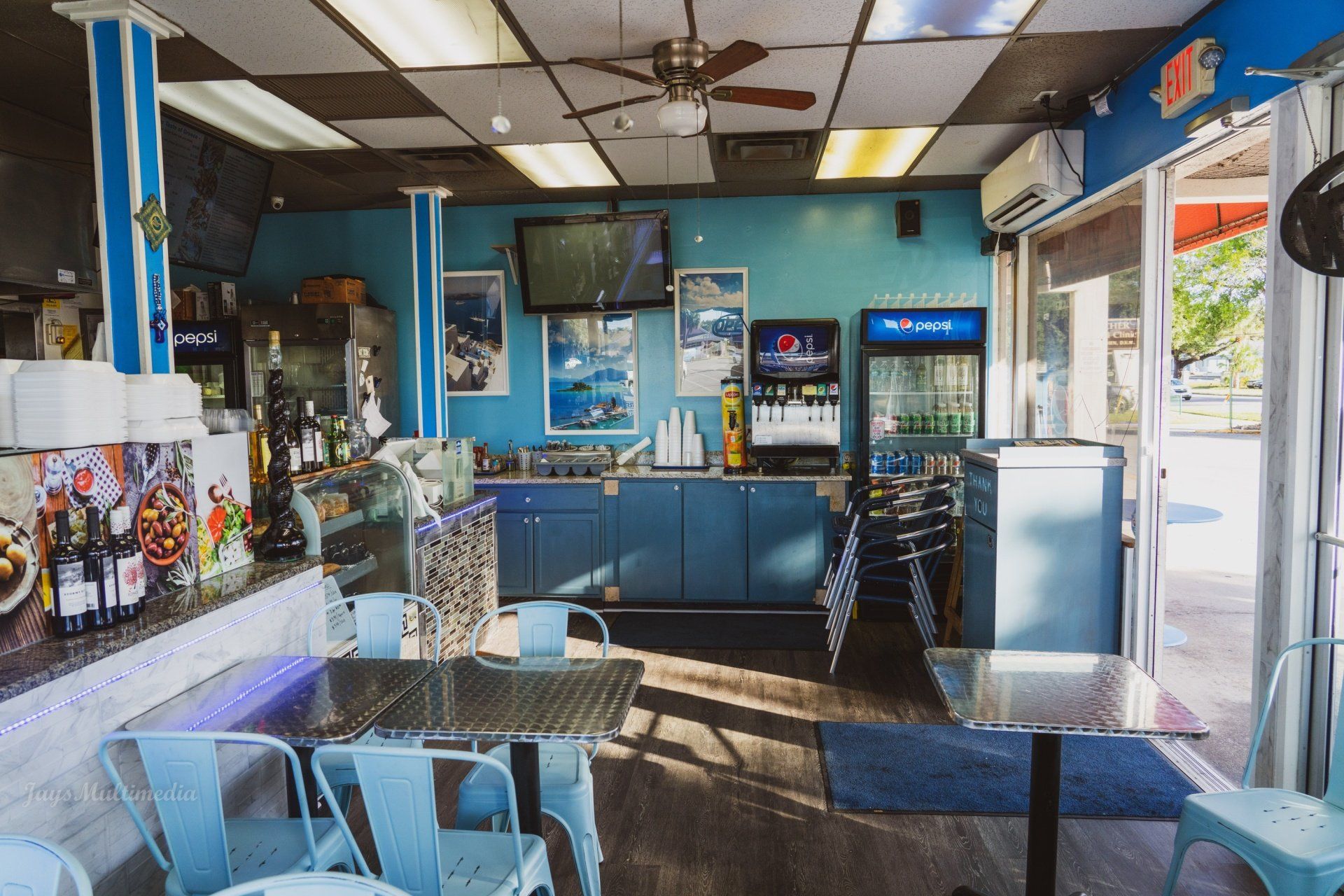 A restaurant with tables and chairs and a pepsi machine