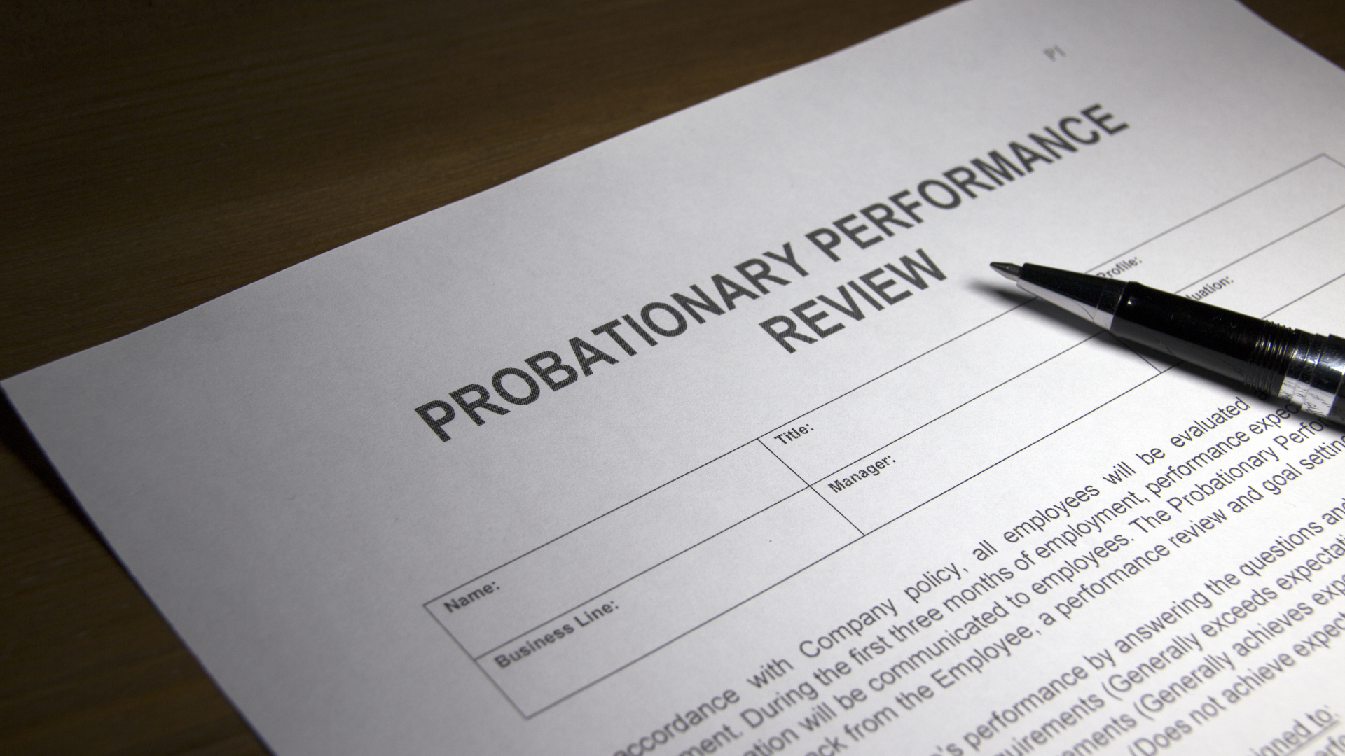 A wooden judge 's gavel is sitting on a wooden table in front of a scale of justice.