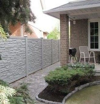 A brick house with a fence and a patio in front of it.