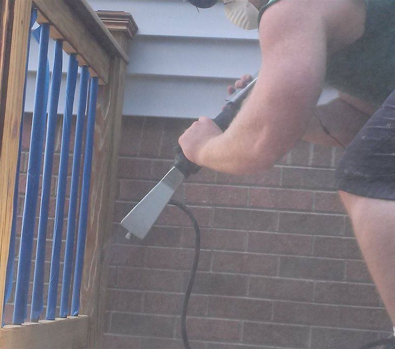 A man is cleaning a brick wall with a vacuum cleaner