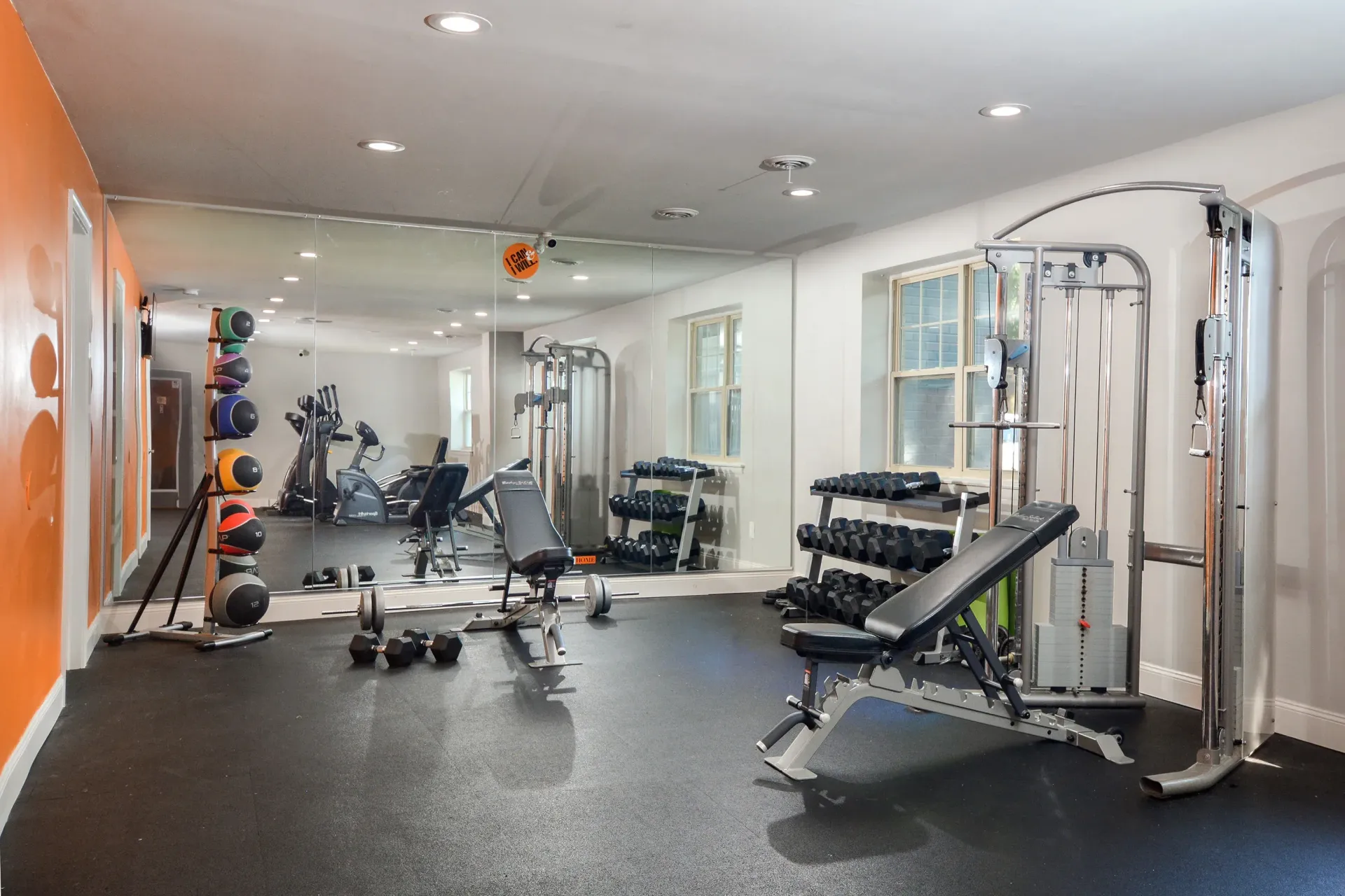 Fitness center in a communal gym with weights, bench, and cardio machines