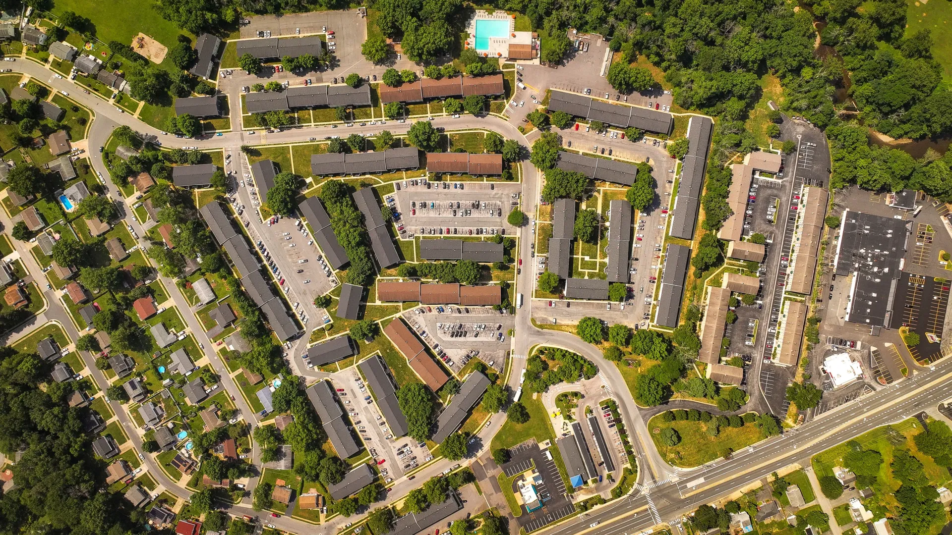 Aerial view of a large apartment community with multiple buildings, parking, and green spaces.