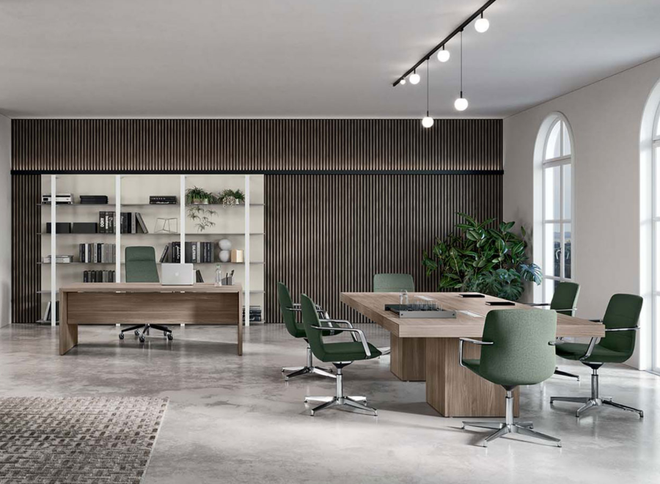 Ufficio moderno con scrivania in legno, tavolo riunioni con sedie verdi, scaffalature a tutta altezza e grandi finestre ad arco.