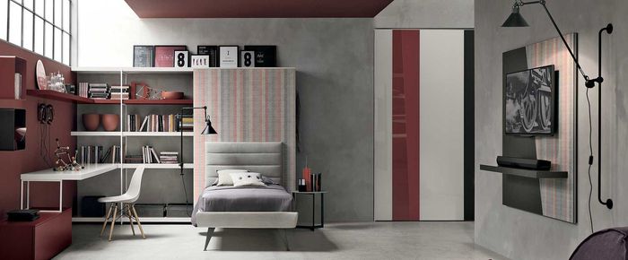 Camera da letto moderna con scrivania bianca, libreria, letto singolo e TV a parete, caratterizzata da dettagli rossi, grigi e in legno.