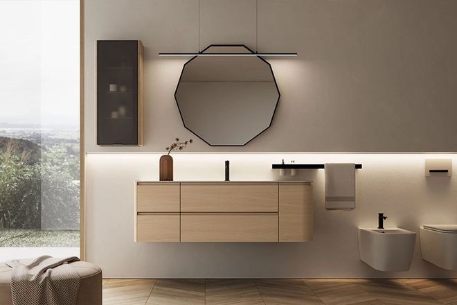 Bagno moderno con mobile lavabo in legno chiaro, specchio decagonale, bidet e WC sospesi e illuminazione d'accento calda.