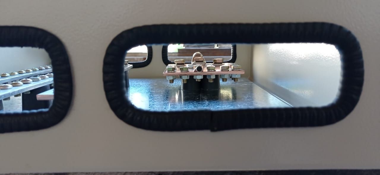 Boquilla de la impresora 3D extruyendo filamento azul a través de una pequeña ventana de visualización ovalada.