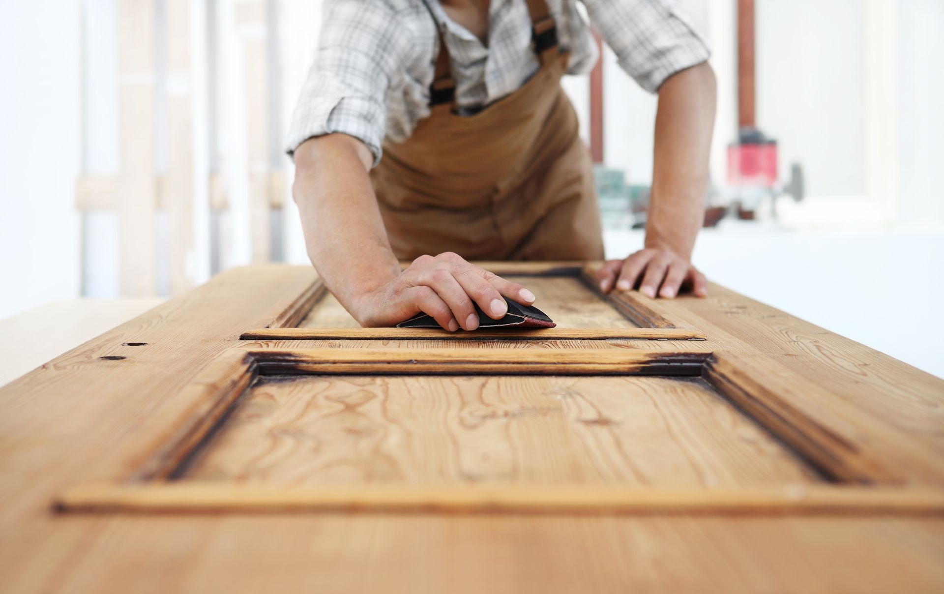 Person sanding a wooden door