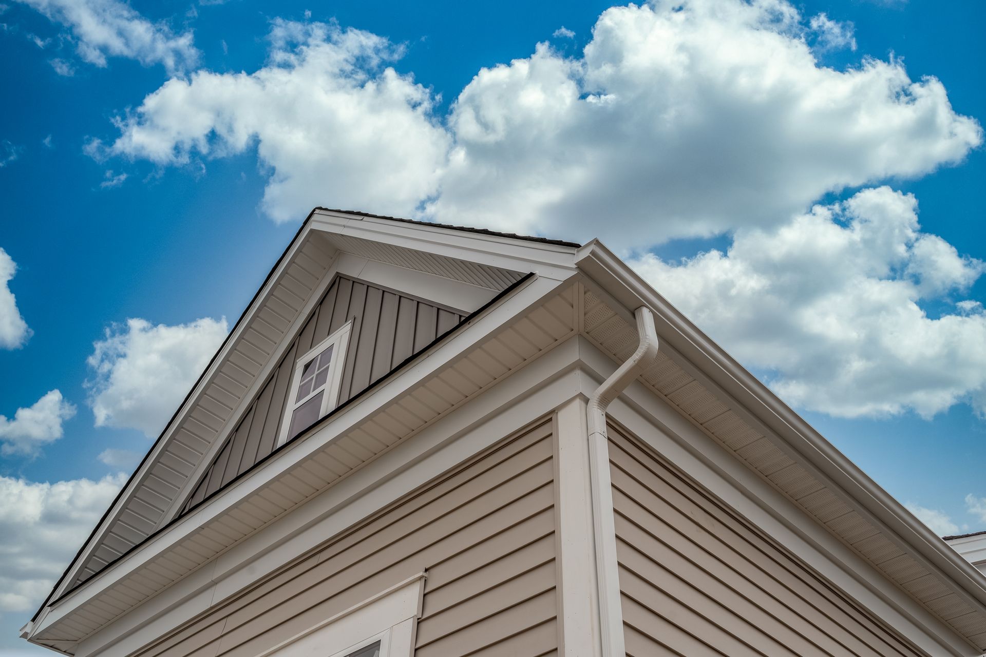 Beige house exterior with a gabled roof