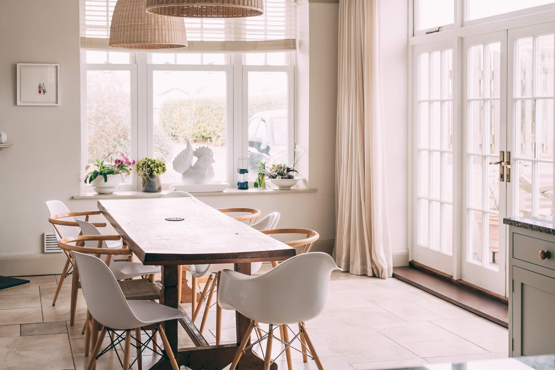 Dining room with a long wooden table and white chairs