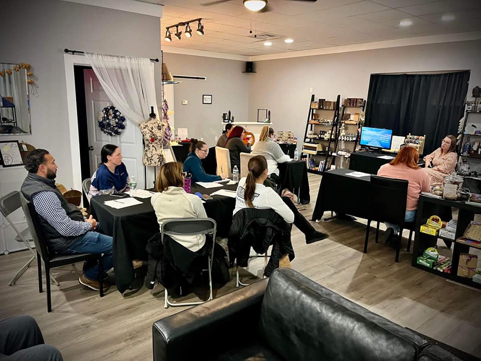 a group of people are sitting at tables in a living room .