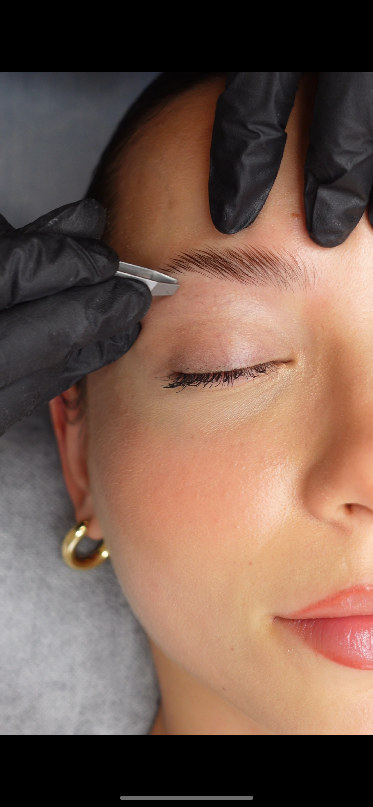 Eine Frau lässt sich die Augenbrauen tätowieren.