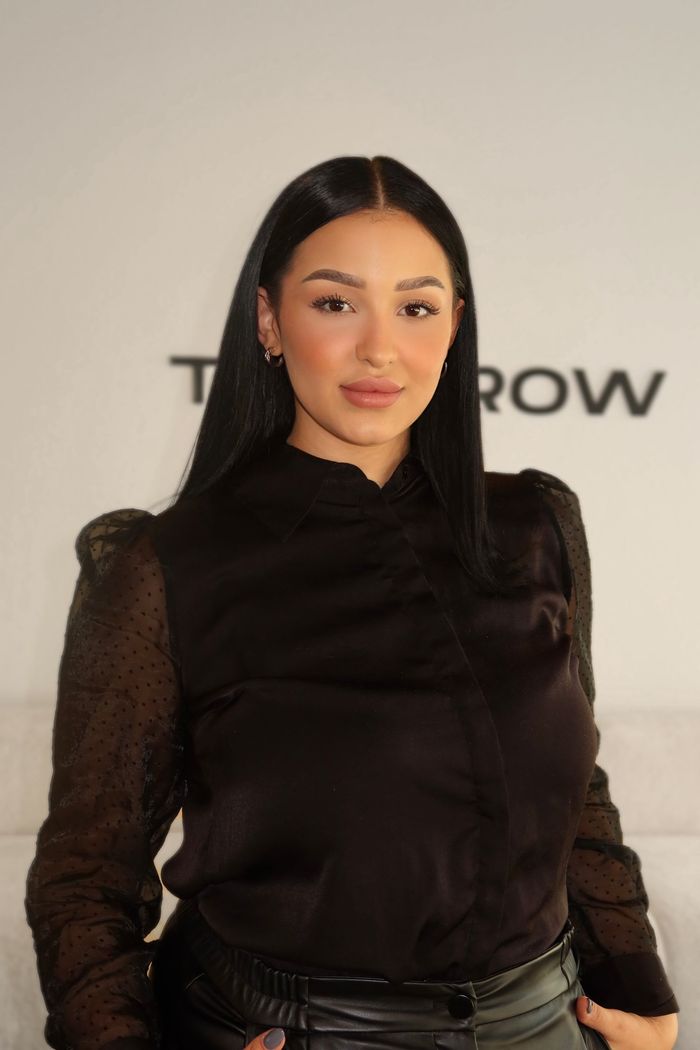 Eine Frau mit einer schwarzen Jacke und einer Kreuzkette