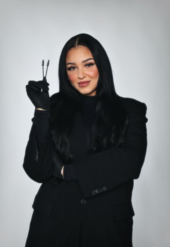 Eine Frau mit einer schwarzen Jacke und einer Kreuzkette