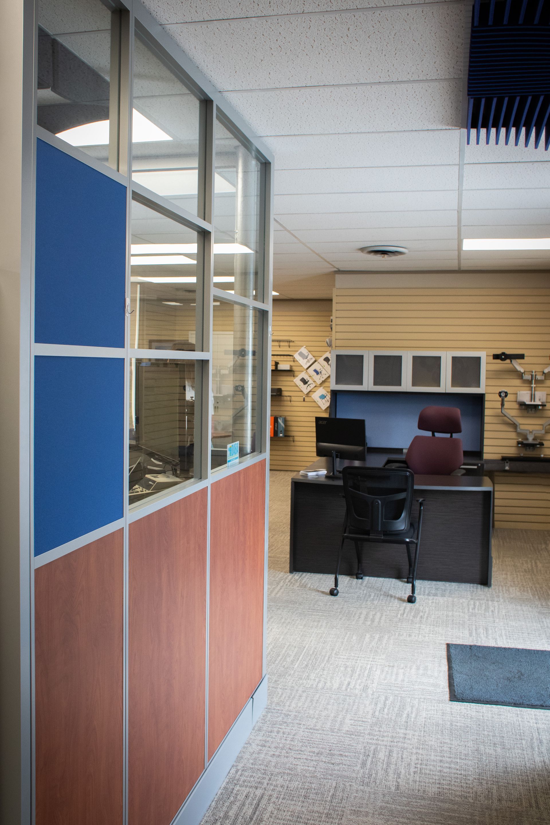 A cubicle in an office with a desk and chair.