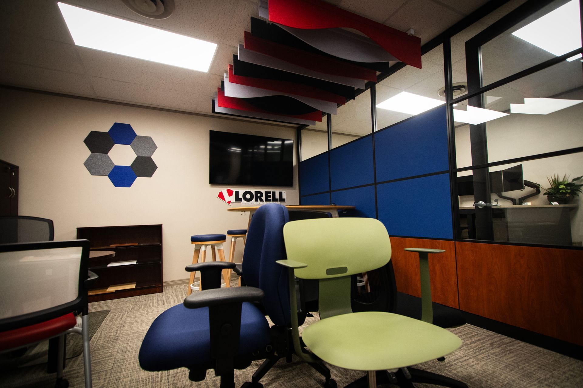 A room with a lot of chairs and a lorell logo on the wall