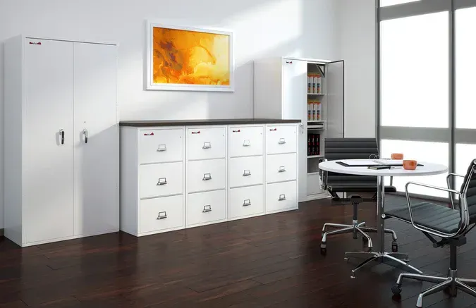 A room with a table , chairs , cabinets and drawers.