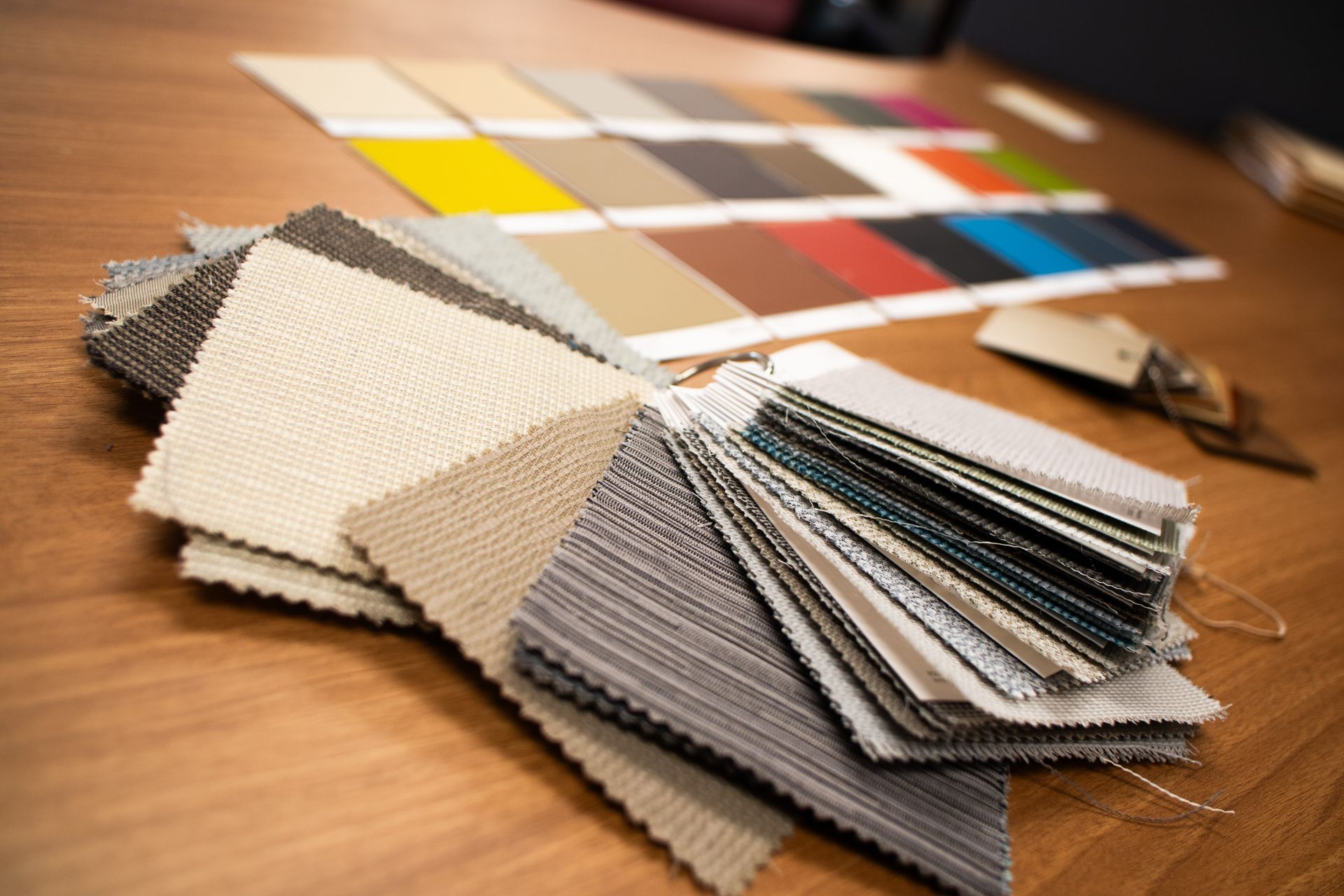 A stack of fabric samples on a wooden table.