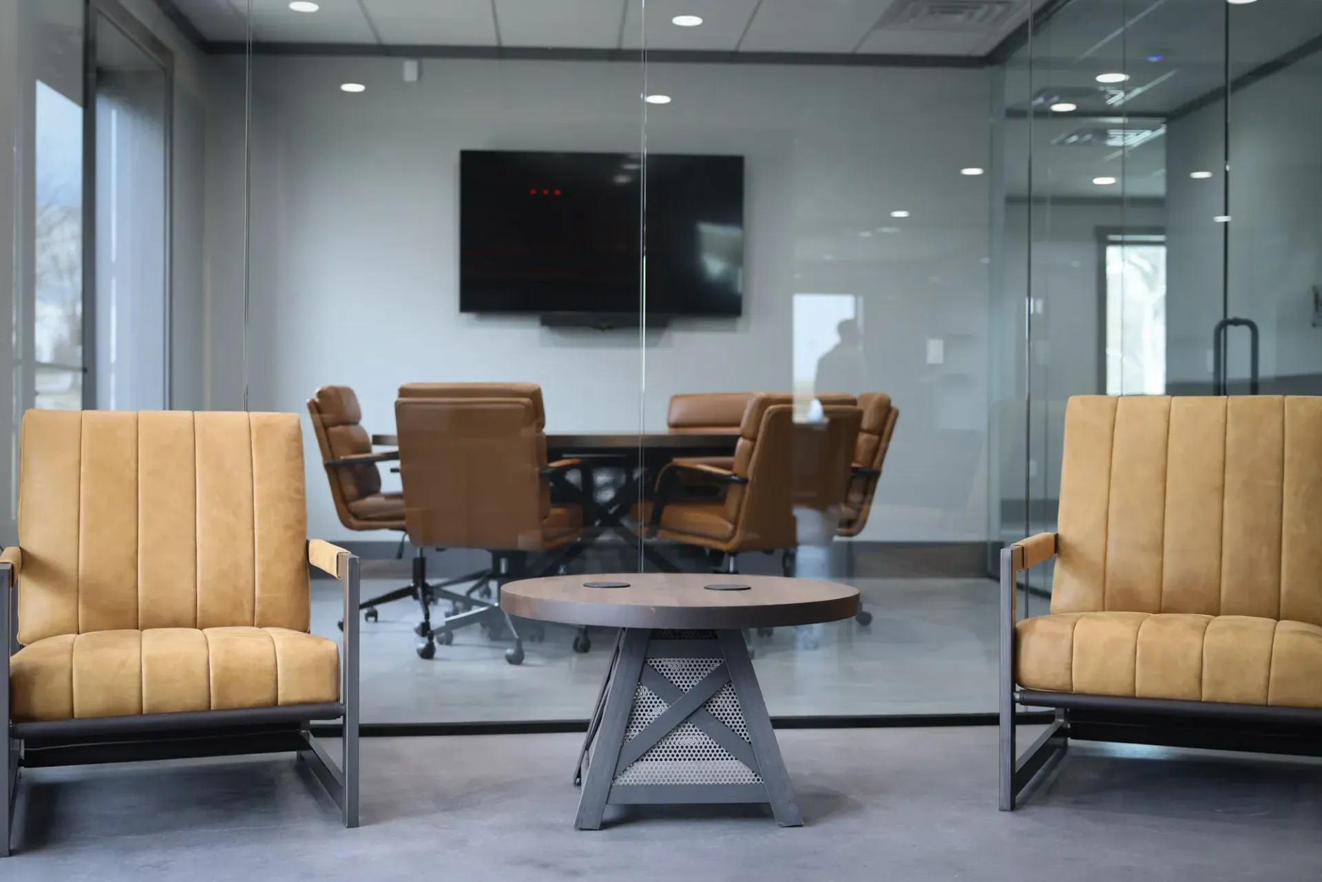 A conference room with chairs , a table and a flat screen tv.