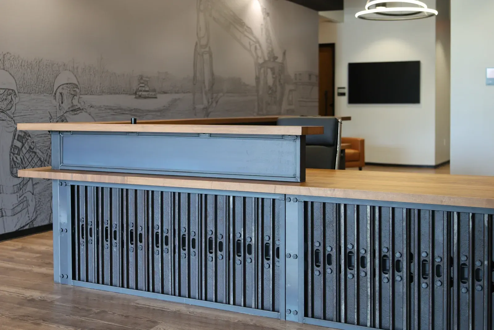 A large wooden counter in a room with a tv on the wall.