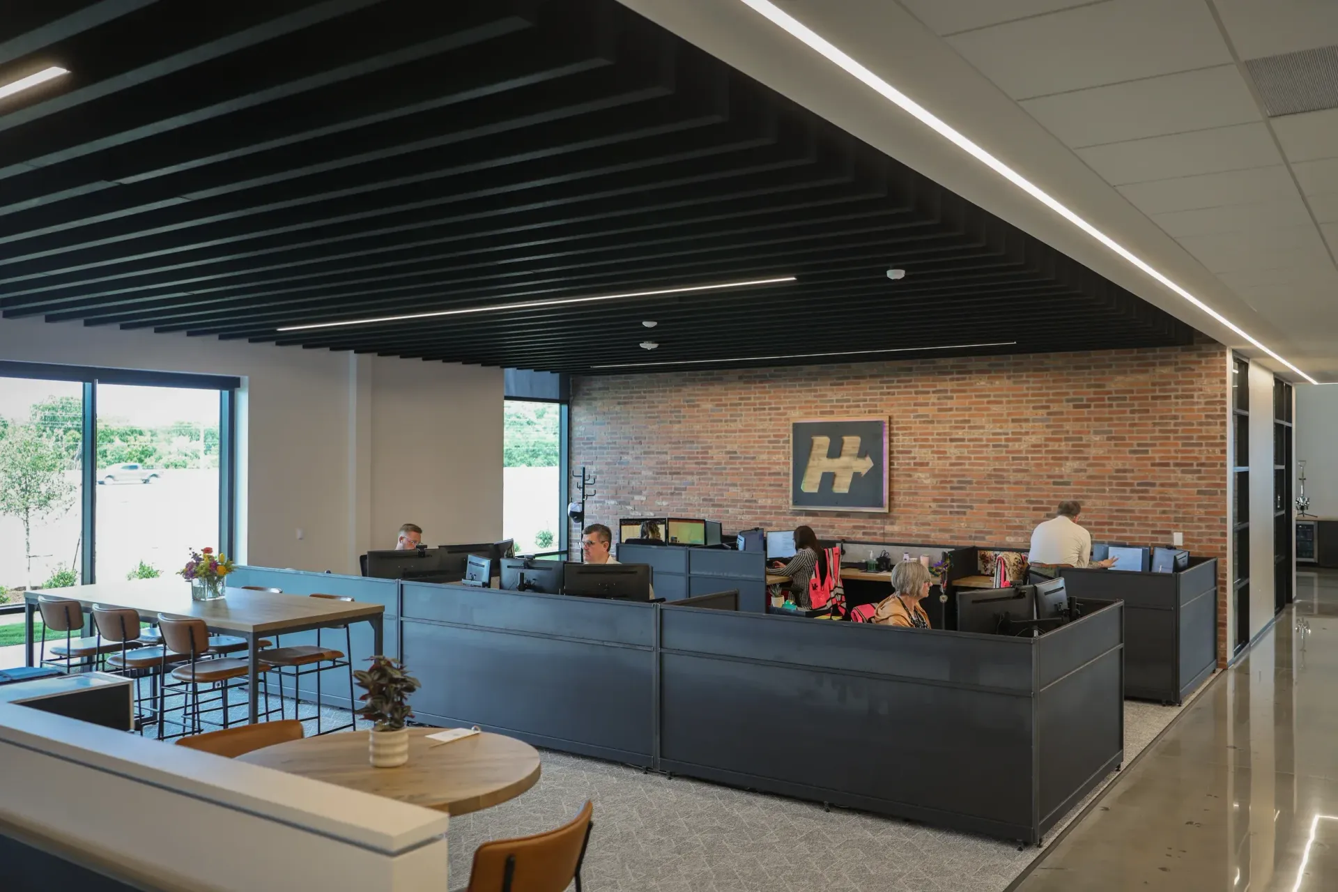 A group of people are sitting at desks in an office.