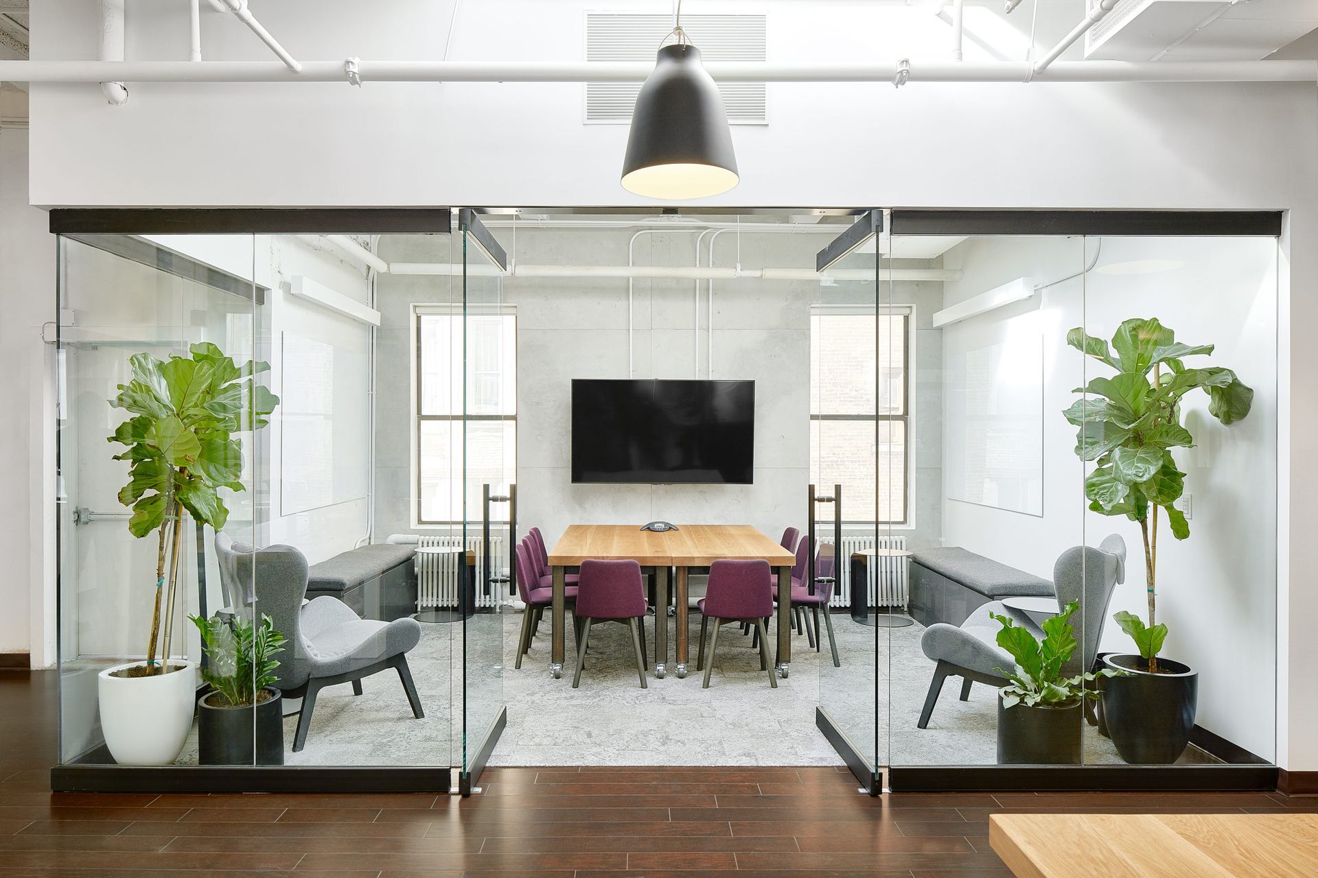 A conference room with a table and chairs and a flat screen tv.