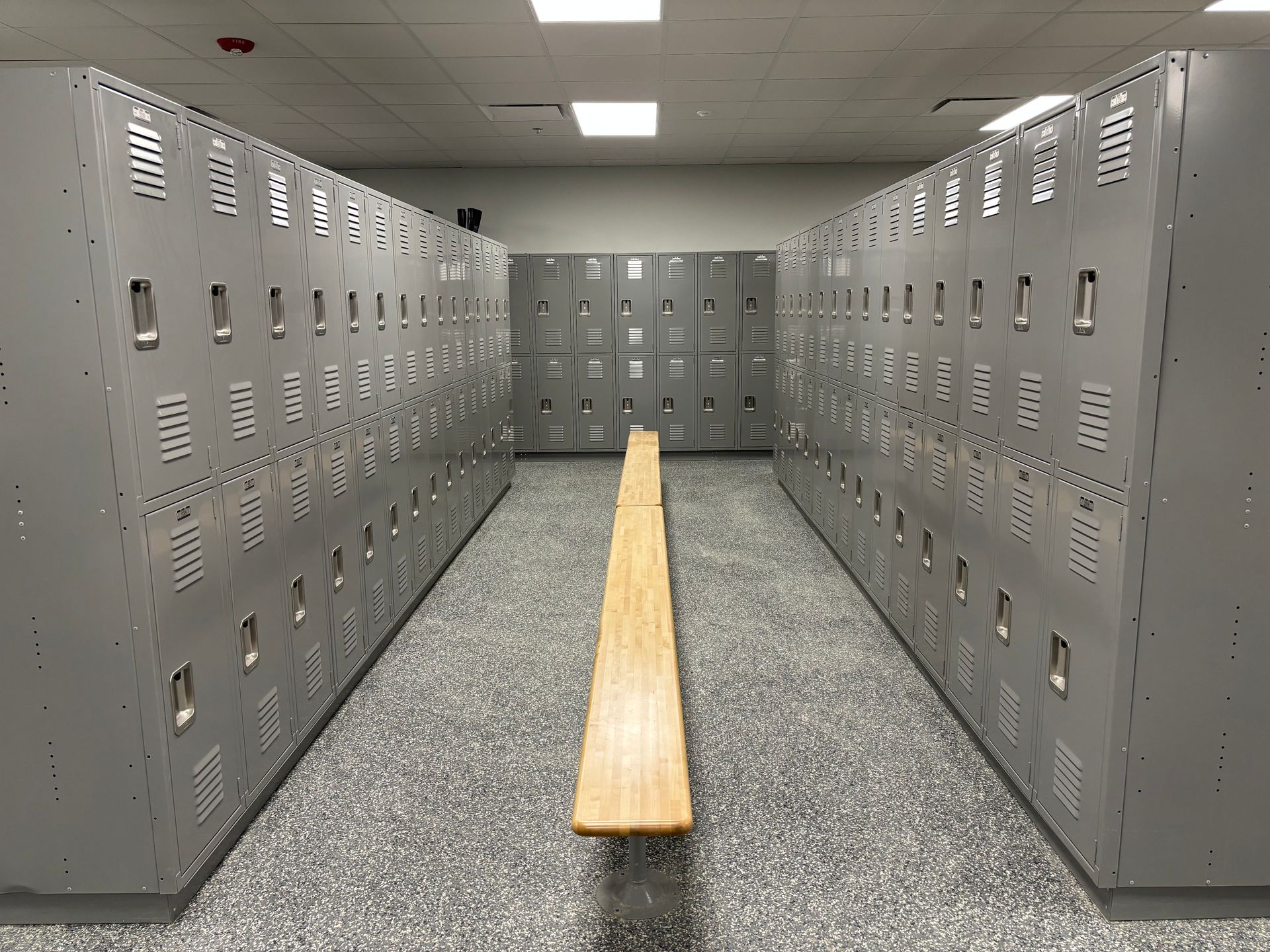 There is a bench in the middle of the locker room.