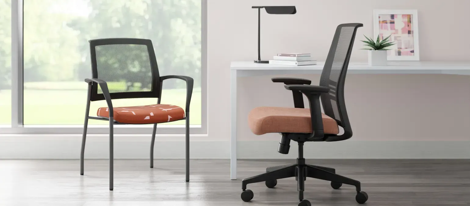 Two chairs are sitting next to each other in a room next to a desk.
